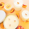 Tangerine and Peach Tea candles in white vessels and wooden wicks - Orange backgound with peaches