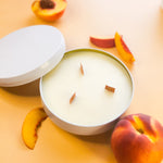 Tangerine and Peach Tea 3-wick candle in white metal tin, with wooden wicks - Orange backgound with peaches